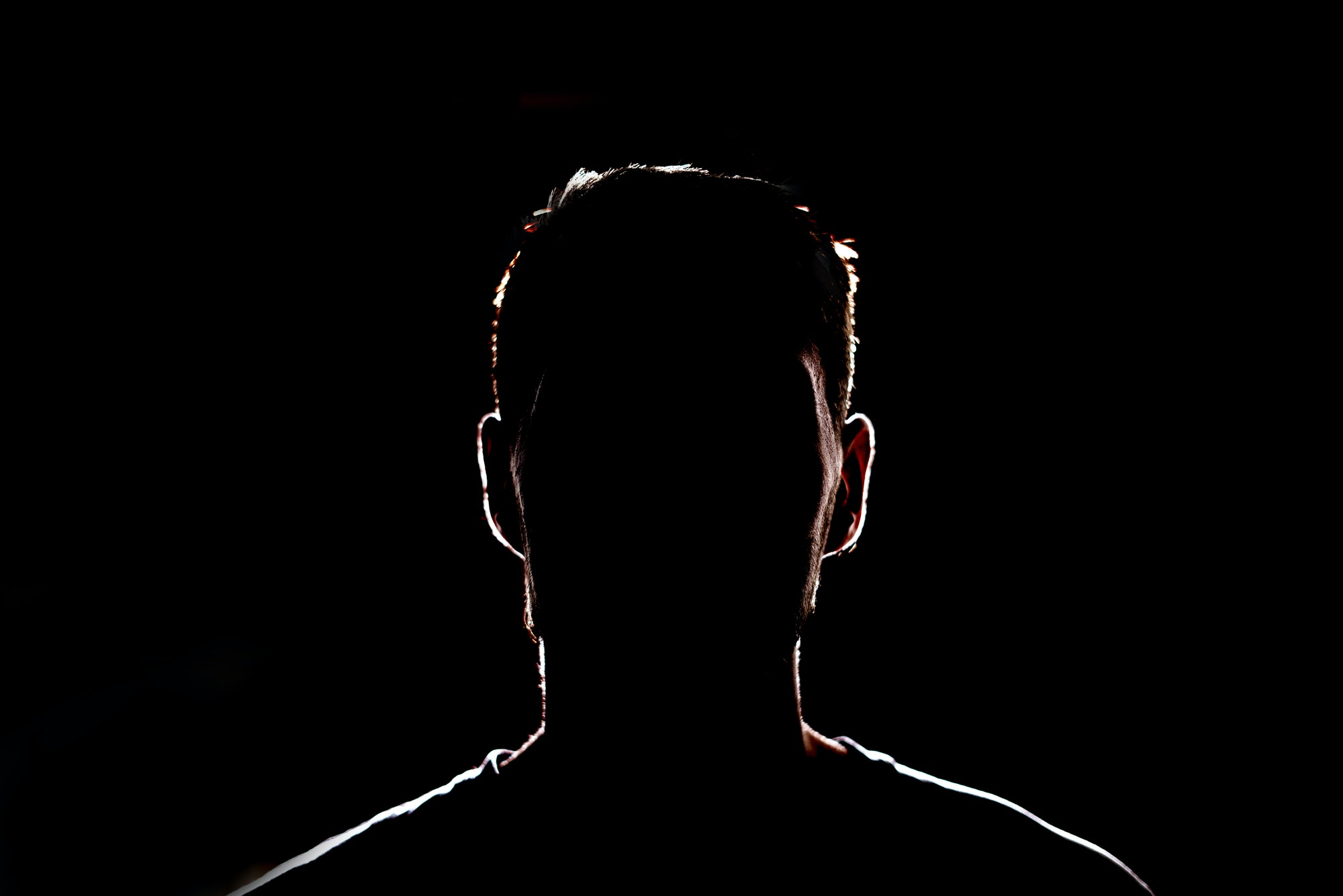 a dark backlight shadow silhouette of male person, incognito unknown profile